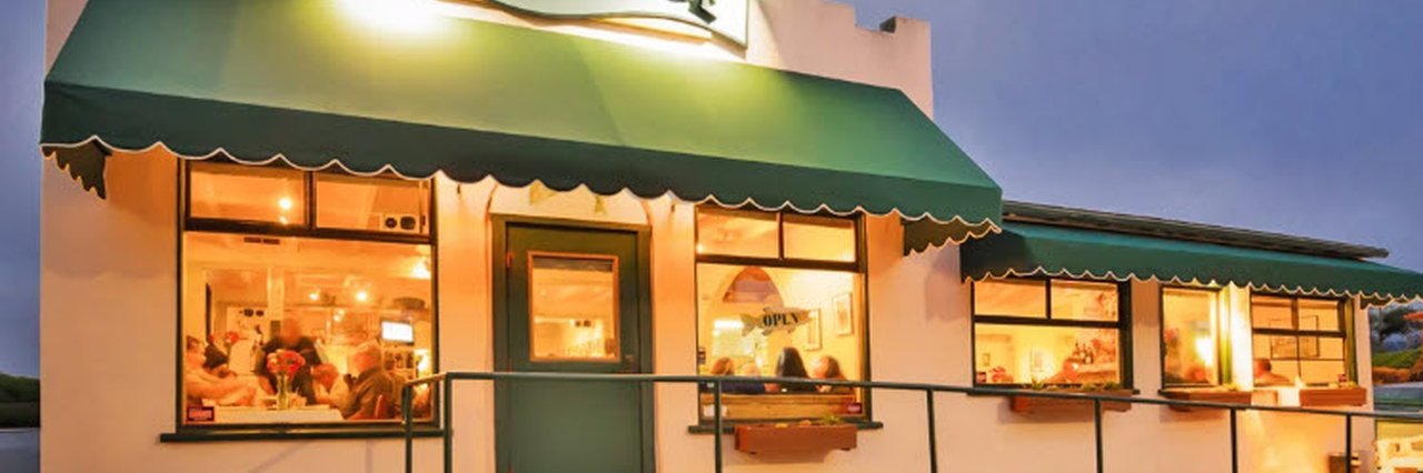 Monterey Restaurant with green awning and warm evening lights.